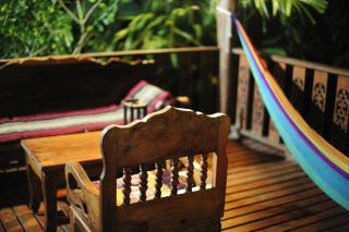 Terrasse couverte d'une case créole ouverte sur un jardin tropical